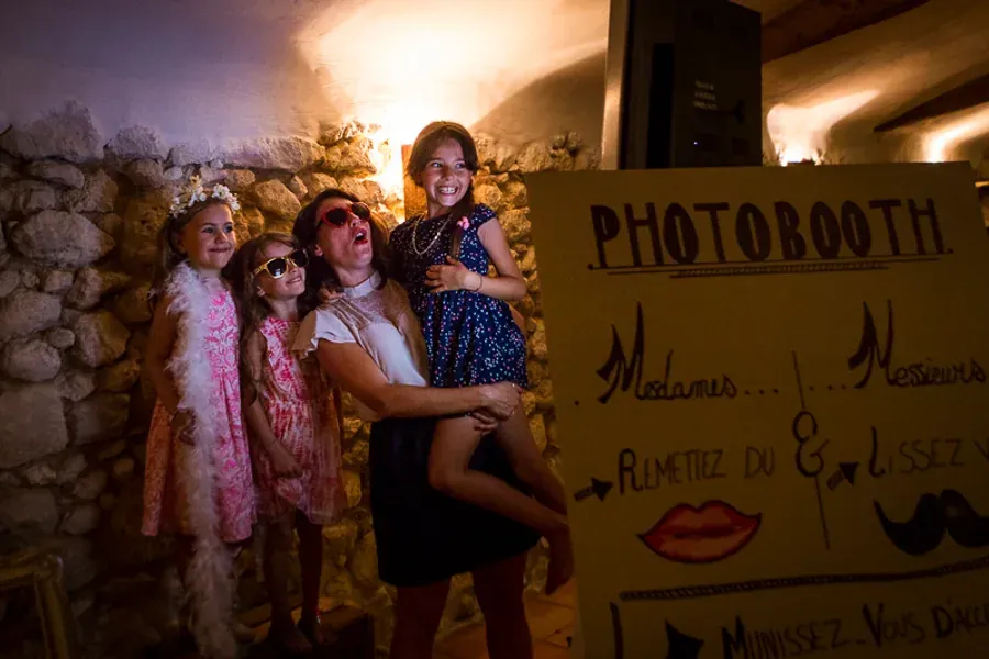 Invités posant devant le panneau d'accueil du photobooth lors d'une réception